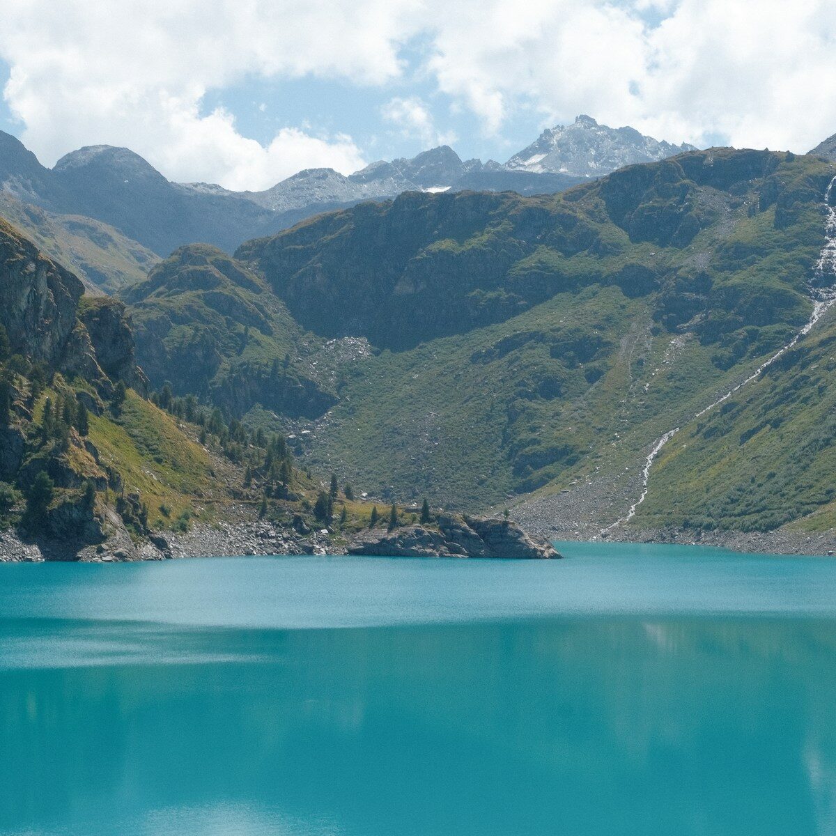Photo by Geoffrey Chevtchenko a body of water with mountains in the back