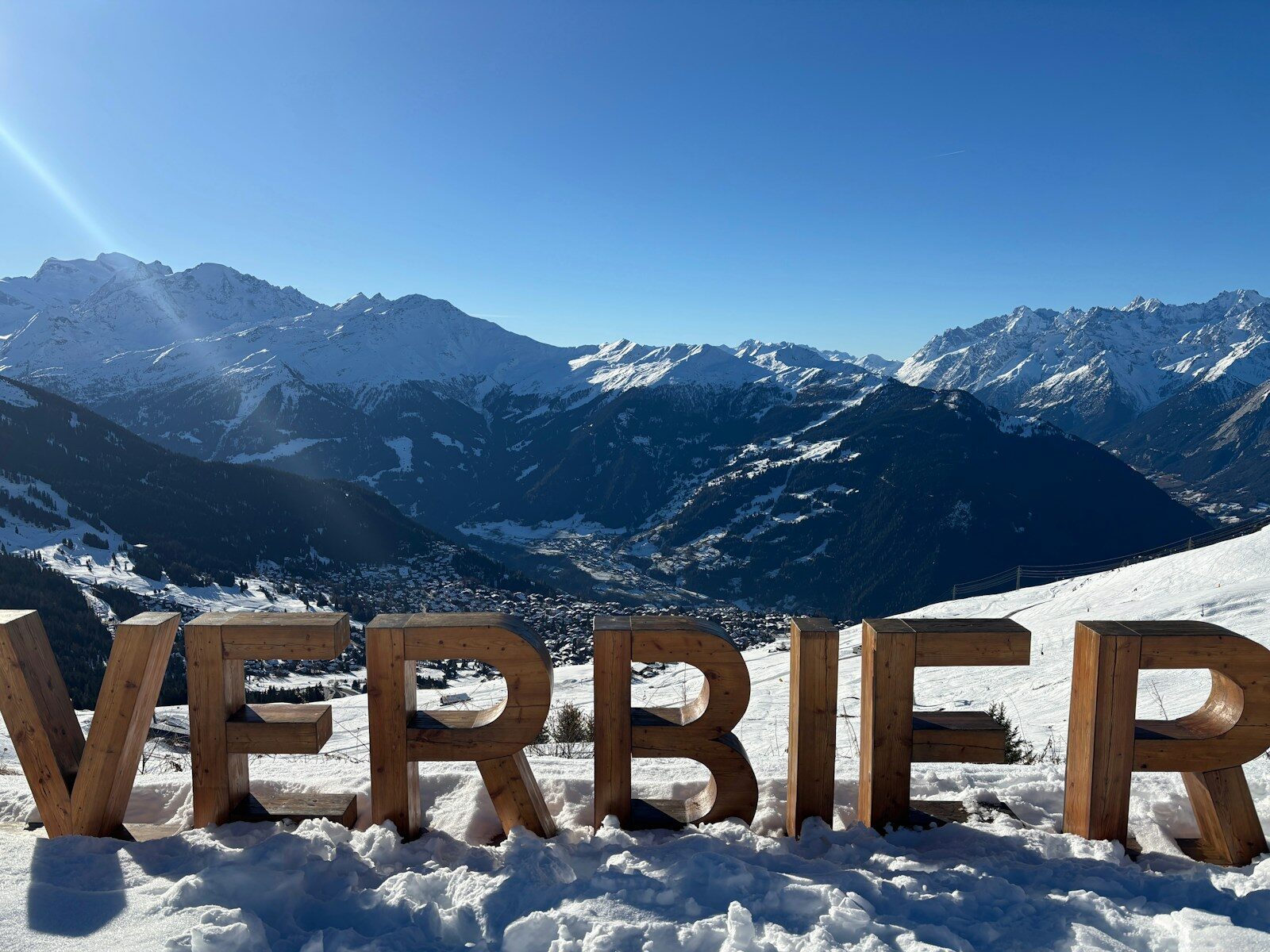 Photo by Peter Burdon Large wooden letters spell verbier with snowy mountains behind