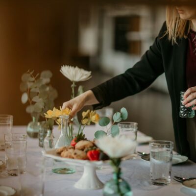 woman in black blazer holding bouquet of flowers
